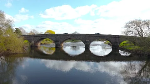 Wide shot of vehicles including van and sedan driving on long stone bridge over Vidéo 337637526