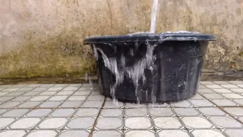 Wide shot of water continuously pouring into and overflowing Stock Footage 333249583
