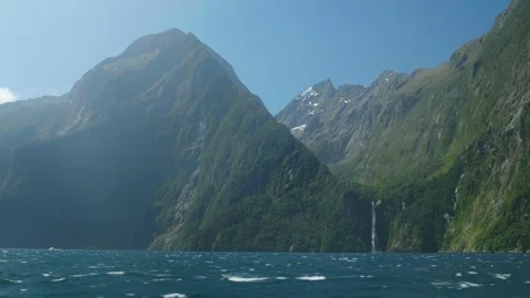 Wide shot of waterfall below mountains at Milford Sound Stock Footage 260371384