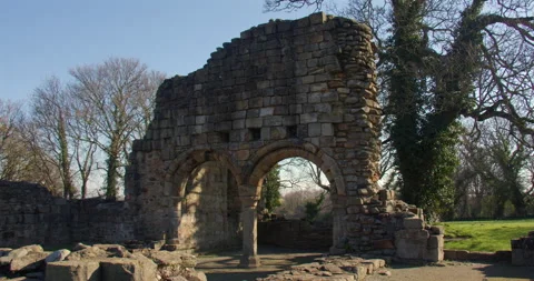 Wide shot of west side of the stone arches at Basingwerk Abbey Stock Footage 344813138