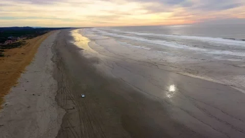 Wide shot of white electric crossover vehicle driving away from sunset Stock Footage 146433167