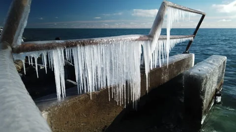 Wide shot of winter ice formations hanging on an iron railing by the Stock Footage 169102029