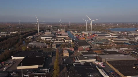 Wide slow aerial approach to wind turbines and port Stock Footage 335658661