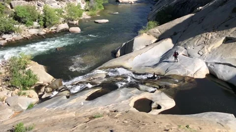Wide Slow-Mo of Man Sliding Down Waterslide into River Stock Footage 201103124