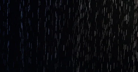 Wide, slow motion looping clip of rain falling on dark background at night 4K Stock Footage 109425409