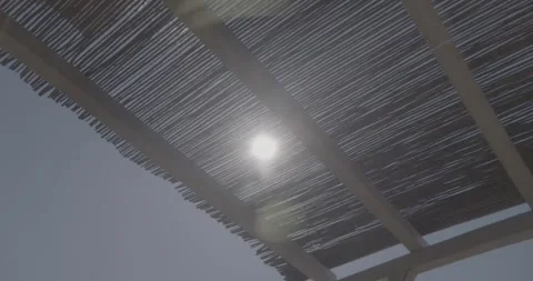 Wide Slow Motion Sun Flare Through Straw Roof – Ungraded 4K S-Log3 Stock Footage 320104983