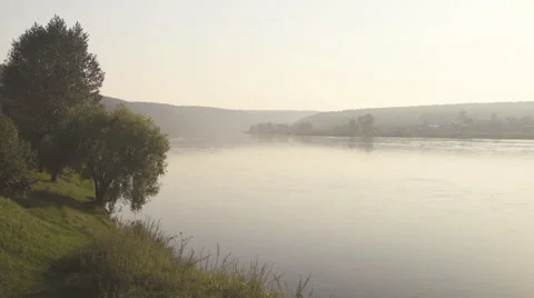 Wide smooth deep river flows slowly in large valley in morning mist Stock Footage 64583742
