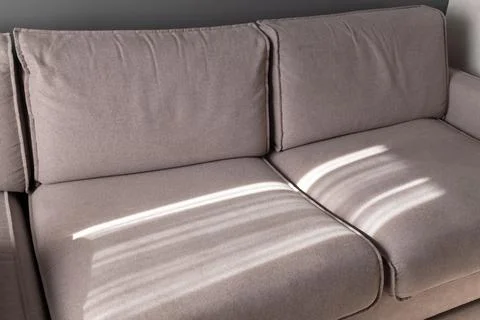 Wide sofa with sunlight pattern on it Stock Photos