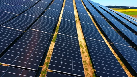 Wide solar array on slope above patchwork farmland Stock-Footage 335695147