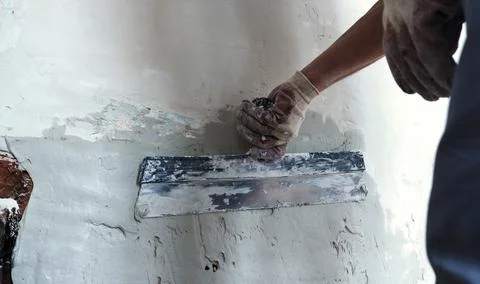 Wide spatula in the working process of plaster Stock Photos