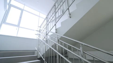 Wide staircase leads toward bright window in modern building Stock Footage 334683018