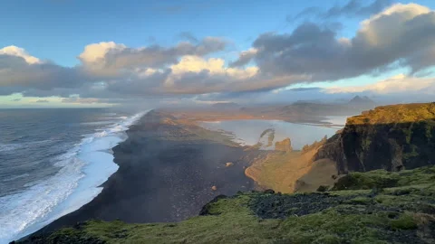 Wide static panoramic view of black sand beach and coastal lagoon at sunset.. Stock Footage 327683777