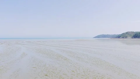 Wide static shot of Binic Beach during low tide on a clear summer day in Stock Footage 346674017