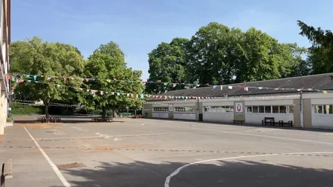 Wide static shot of an empty school courtyard with classroom buildings, trees Video stock 346810502