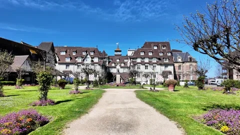 Wide static shot of a grand half-timbered building and a vibrant spring garden u Vídeos de archivo 332803901