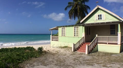 Wide static shot of green beach house on Maxwell beach in Barbados Stock Footage