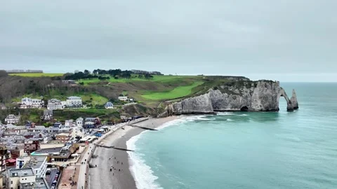 Wide static shot of the iconic cliffs and sea arch of Étretat under a cloudy sky Vídeos de archivo 332861958