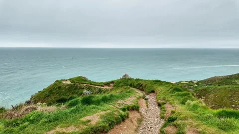 Wide static shot of the iconic cliffs and sea arch of Étretat under a cloudy sky Vídeos de archivo 332861959