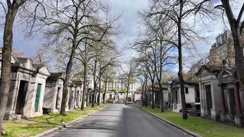 Wide static shot of a main path in the Père Lachaise Cemetery Vídeos de archivo 332676117