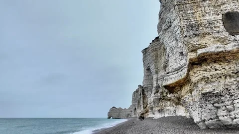 Wide static shot of the massive white limestone cliffs and pebble beach in Étret Vídeos de archivo 332860293