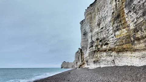 Wide static shot of the massive white limestone cliffs and pebble beach in Étret Vídeos de archivo 332860304