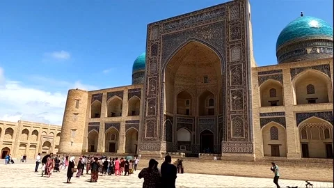 Wide static shot of Mir-i Arab Madrassah with tourists in Bukhara Vídeos de archivo 335539915