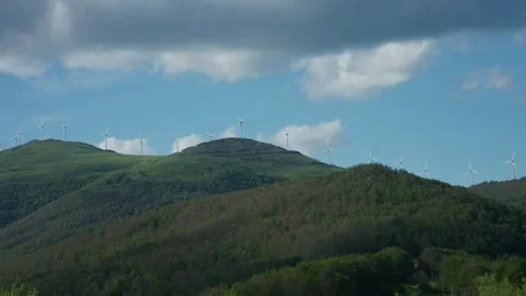 Wide static shot of row of windmills on the top of the mountain generating Video stock 338126890