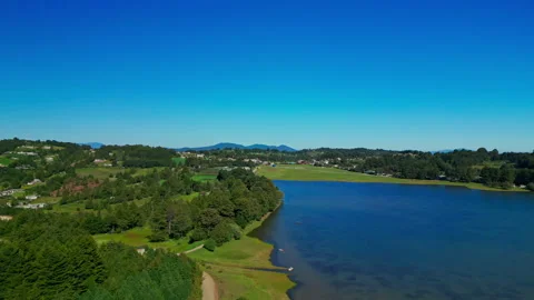 Wide static view of a reservoir shoreline bordered by green hills Stock Footage 346015181