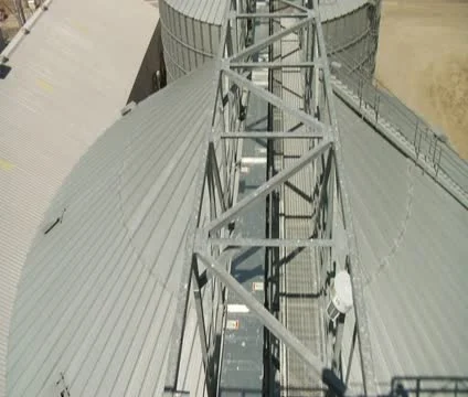 Wide tilt upshot of grain elevators with fields in distance Stock Footage 21591658