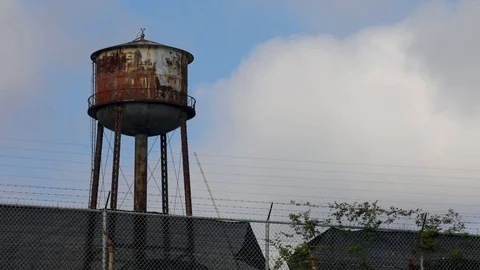 Wide Timelapse of Rusty Water Tower with Blue Sky Stock Footage 117705791