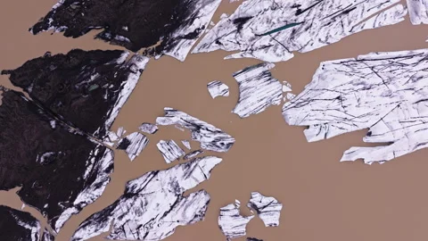Wide top down aerial of brown water by melting glacier in Iceland Stock Footage 342480084