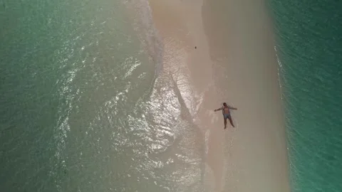 Wide top down aerial view of man relaxing on a pristine Caribbean sandbar with Vidéo 342955329