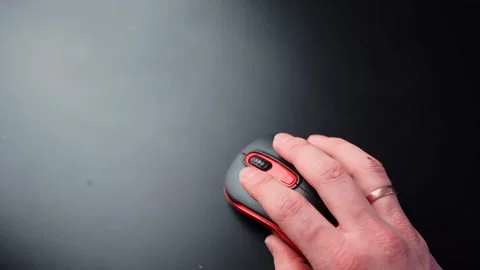 Wide top-down shot of a hand using a black and red wireless mouse on a clean 스톡 동영상 332241832