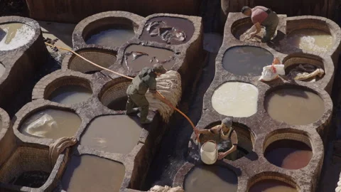 Wide top down shot of tannery leather workers dyeing leather in Fes Stock Footage 265491925