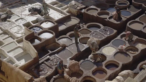 Wide top down shot of tannery leather workers dyeing leather in Fes Stock Footage 265496143