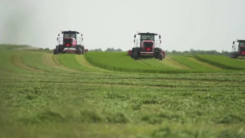 Wide Tracking of 3 Swathers from Behind Stock Footage 221862999