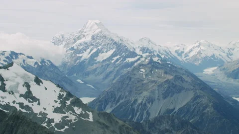 Wide tracking shot of Mount Cook on a cloudy day with foreground mountains Stock Footage 155032805
