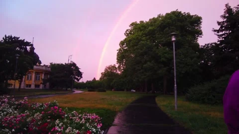 Wide Tracking Shot of Vibrant Double Rainbow over Green Grass Lawn Field and Video stock 337024080