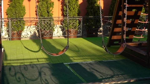 Wide of two swings on a swing set blowing in the wind as the sun sets. amid the Stock Footage 92498865