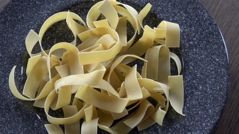 Wide uncooked egg noodles Stock Footage 128166458