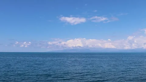 Wide View of the Blue Ocean and Clouds Near the Coastline in a Calm Setting With Stock Footage 330799201