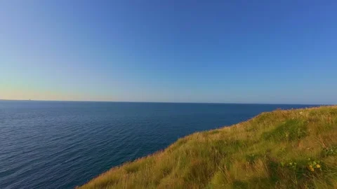 Wide view of blue ocean sea horizon from grassy headland cliff in ireland Stock Footage 340433072