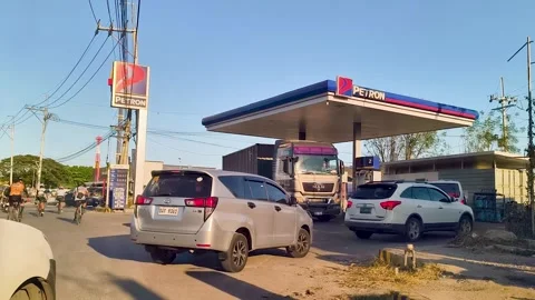 Wide view of busy gas station in the Philippines with long lines of cars during Stock Footage 332601751
