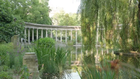 Wide View of Classical Corinthian Colonnade and Weeping Willow Reflecting in a P Stock Footage 340476992