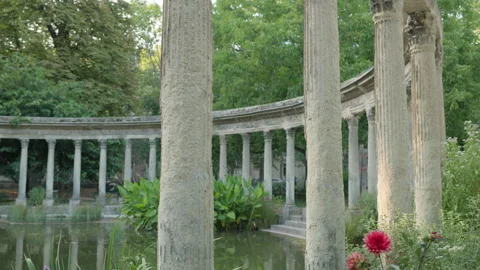 Wide View of Classical Corinthian Colonnade framing Pond and Red Flowers Stock Footage 340477306