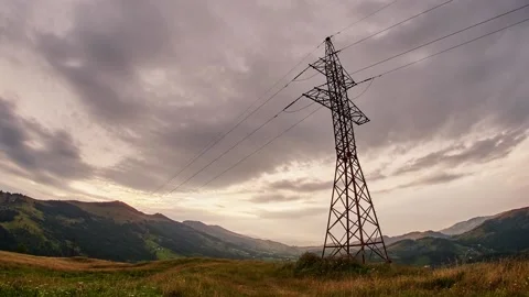 Wide view of clouds passing behind power line pylon in sunset sky background Stock Footage 132696495