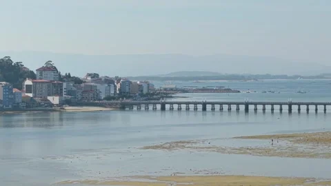 Wide view of a coastal town in O Grove, Spain, featuring a long pedestrian Stock Footage 346723170