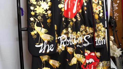 Wide view of a completed gold and black textile panel displayed on a rack in a Stock Footage 339124427