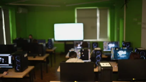 Wide view of a computer lab with multiple workstations and students working Stock Footage 332619963