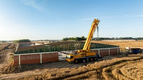 A wide view of a construction site with a mobile telescopic crane lifting gre Stock Photos